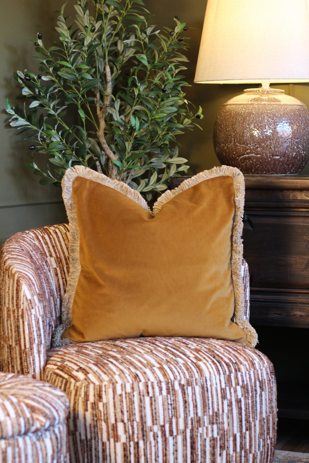 Langford Whiskey fringed velvet cushion in a warm whiskey tone, 55 x 55cm