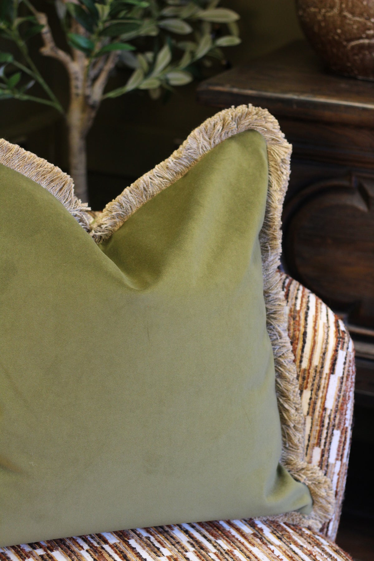 Langford Olive fringed velvet cushion in an earthy olive green, 55 x 55cm