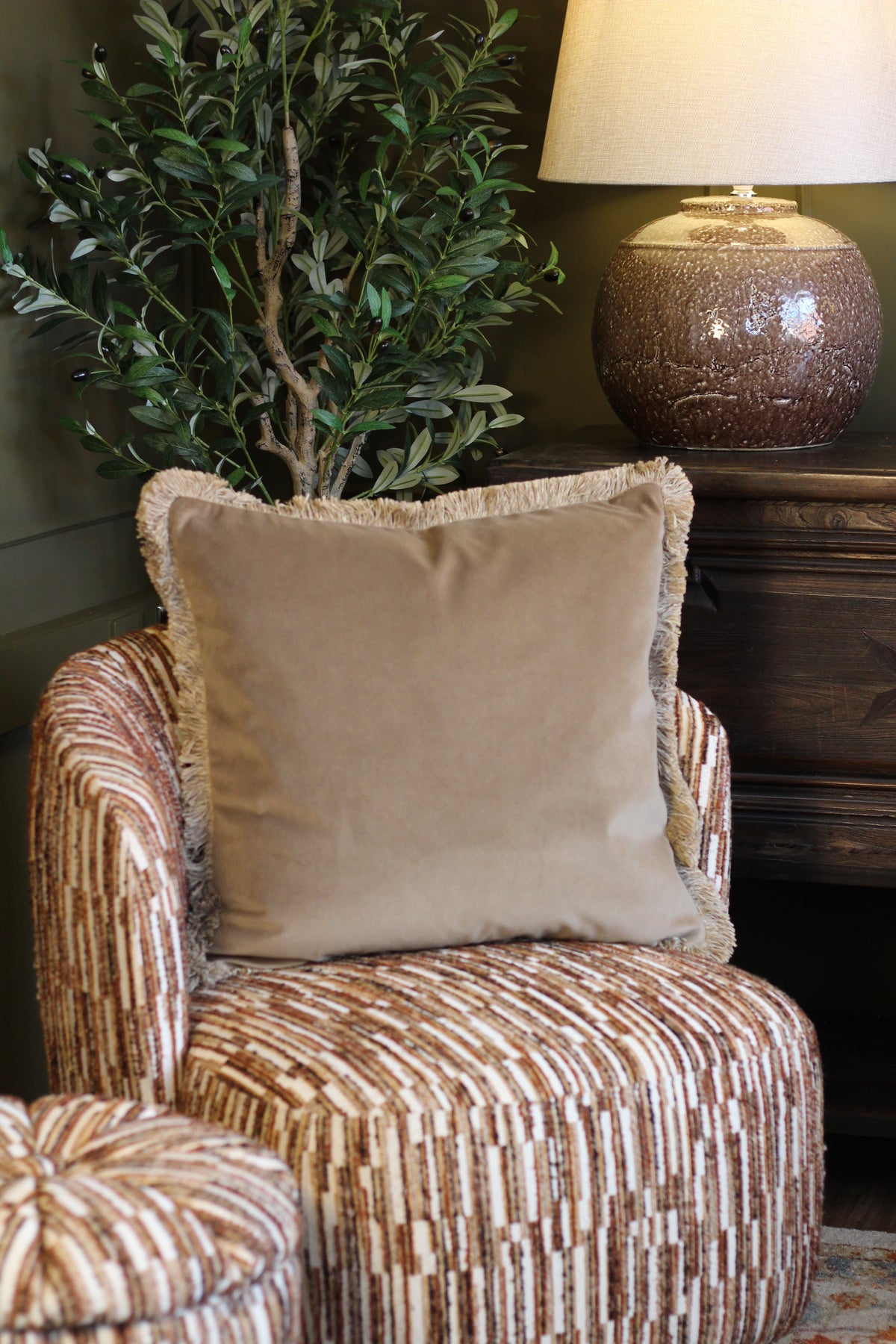 Langford Stone fringed velvet cushion in a warm neutral tone, 55 x 55cm