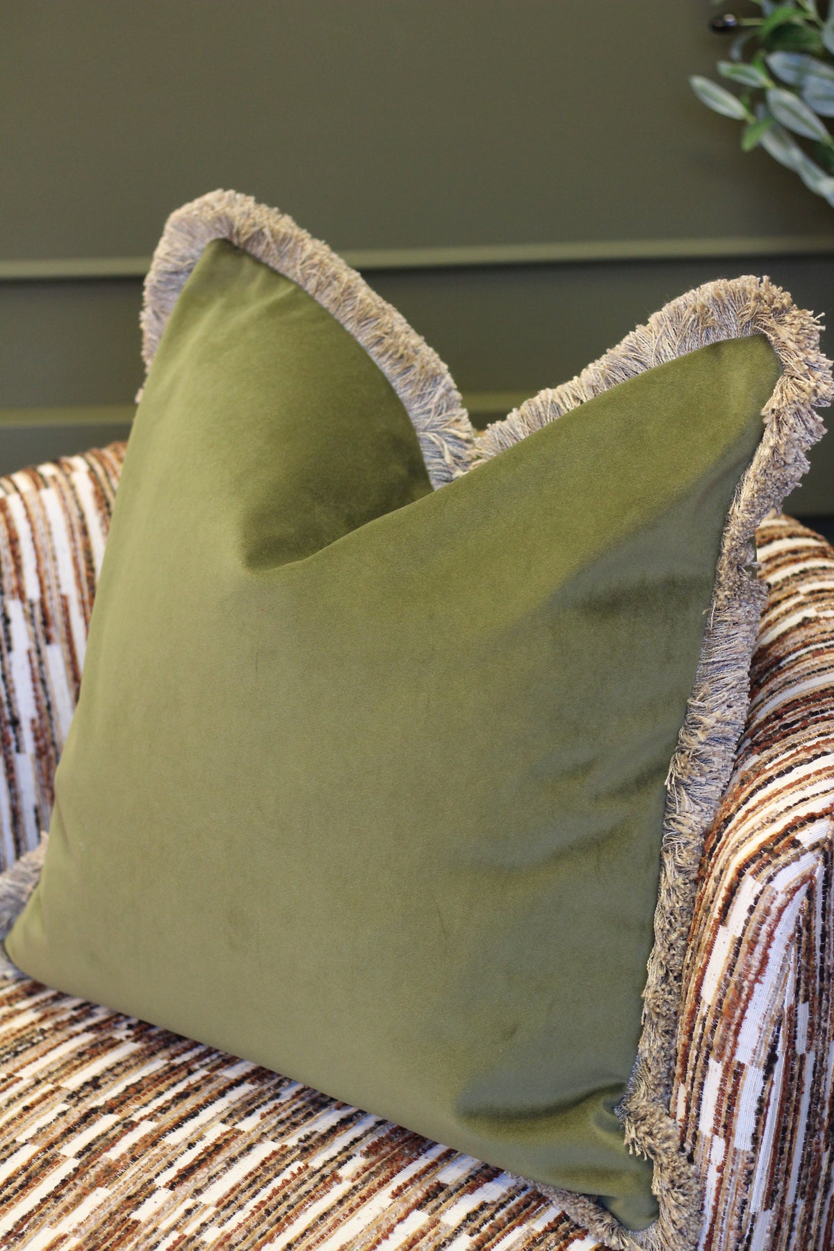 Langford Olive fringed velvet cushion in an earthy olive green, 55 x 55cm