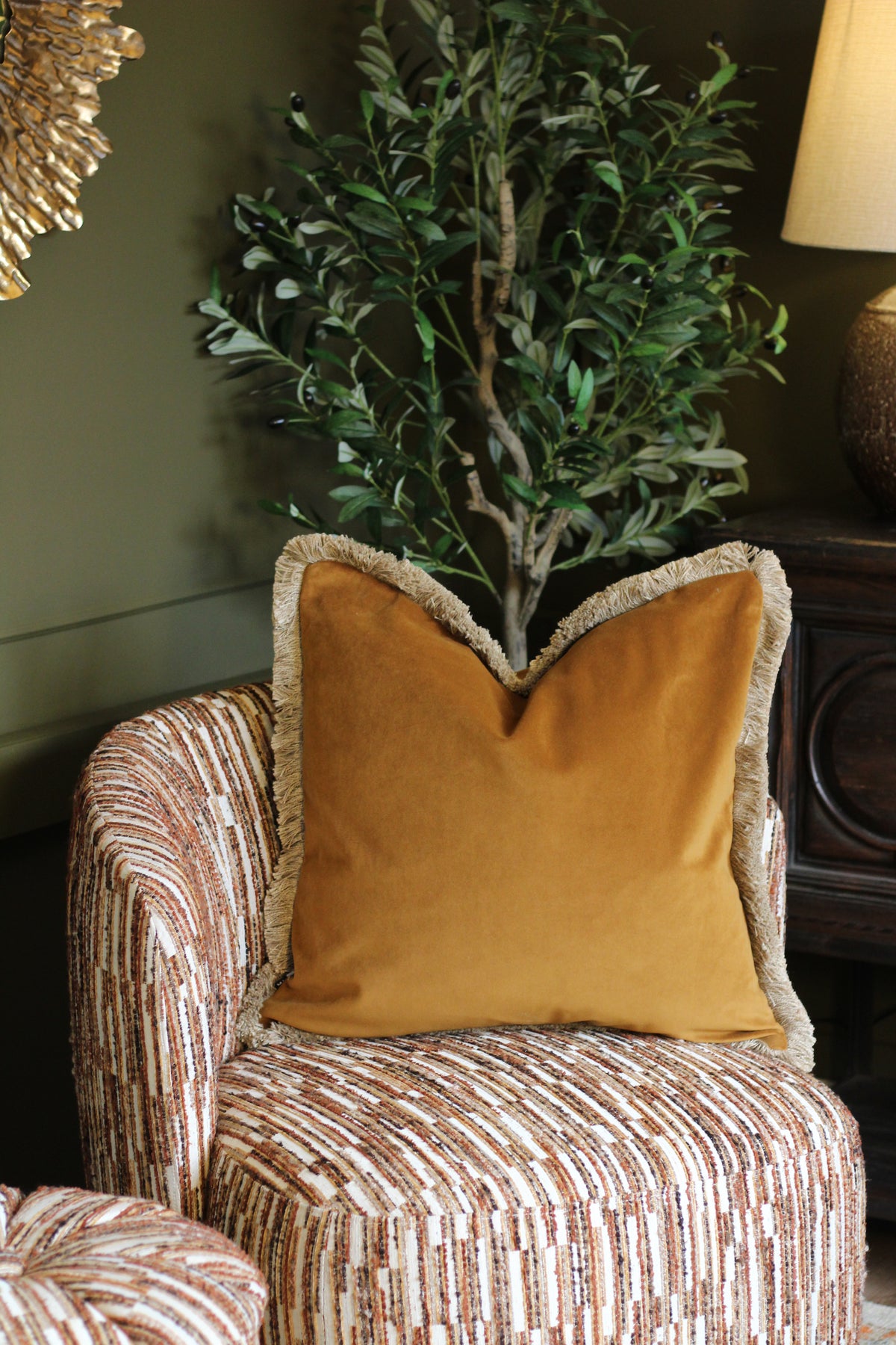 Langford Whiskey fringed velvet cushion in a warm whiskey tone, 55 x 55cm