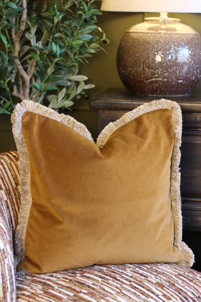 Langford Whiskey fringed velvet cushion in a warm whiskey tone, 55 x 55cm