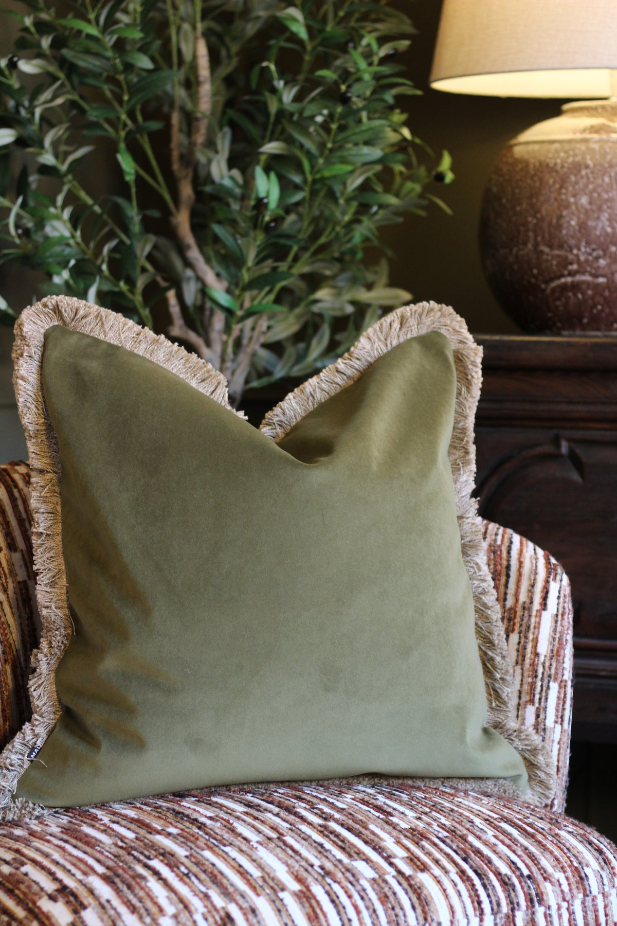 Langford Olive fringed velvet cushion in an earthy olive green, 55 x 55cm