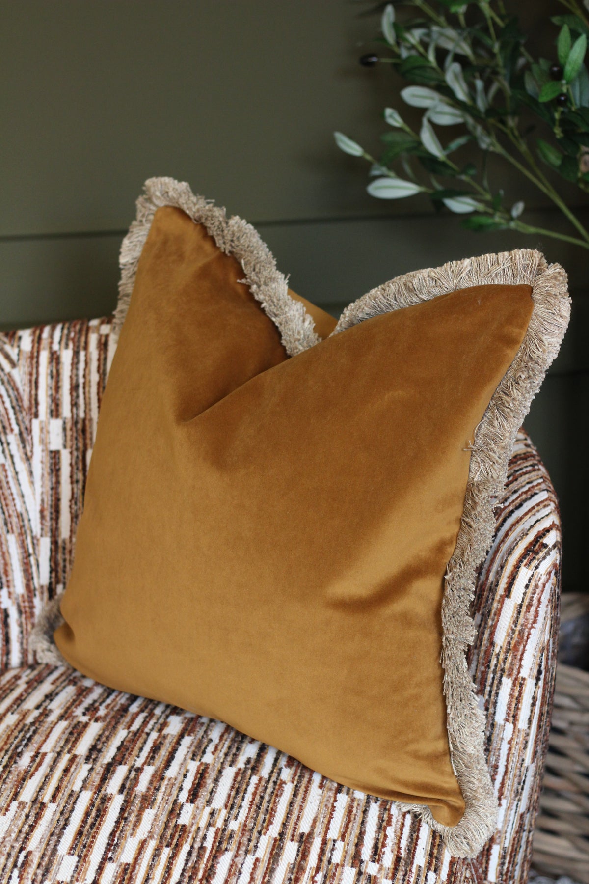 Langford Whiskey fringed velvet cushion in a warm whiskey tone, 55 x 55cm