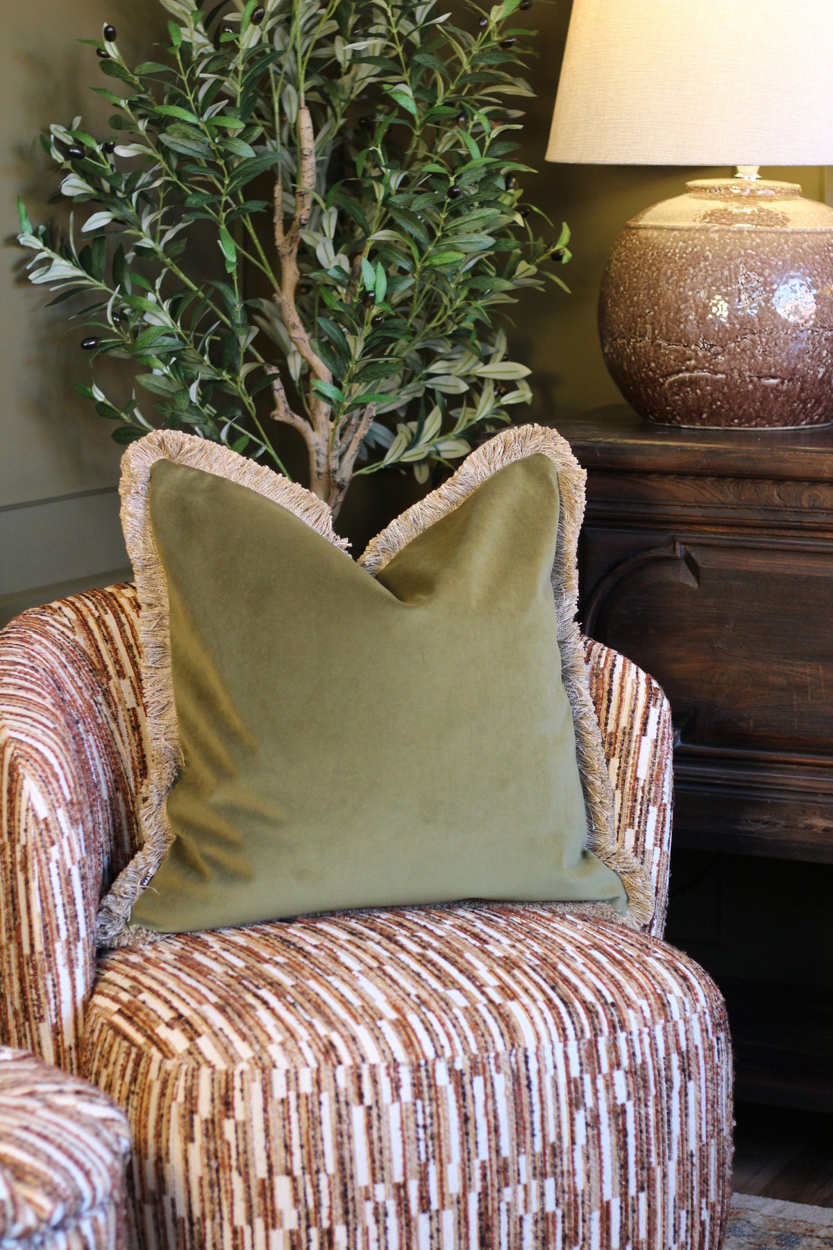 Langford Olive fringed velvet cushion in an earthy olive green, 55 x 55cm