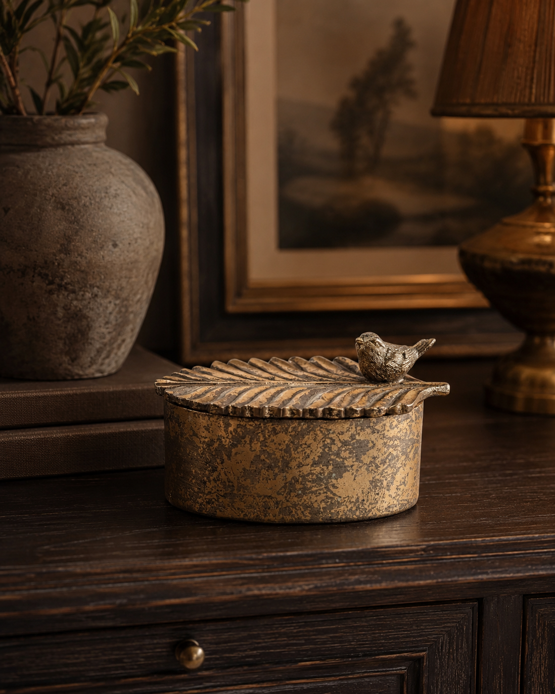Close detail of the bird embellishment and leaf lid on the antique gold trinket box.